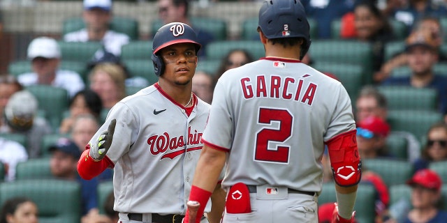 The Washington Nationals' Juan Soto, left, celebrates after scoring with Luis Garcia (2) in a game against the Atlanta Braves at Truist Park July 9, 2022, in Atlanta.