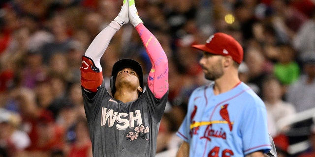 Washington Nationals' Juan Soto, left, gestures beside St. Louis Cardinals first baseman Paul Goldschmidt after he singled during the fifth inning, July 30, 2022, in Washington.