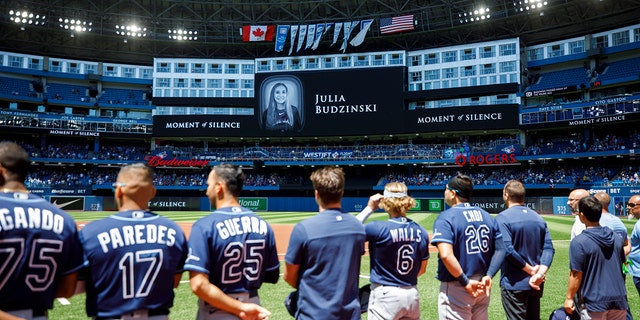 Tampa Bay Rays players and staff stand for a moment of silence on the death of Julia Budzinski, the eldest daughter of Blue Jays first base coach Mark Budzinski, at Rogers Centre on July 3, 2022, in Toronto, Canada.