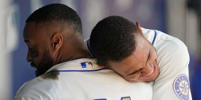 Seattle Mariners' Carlos Santana, left, is hugged by Julio Rodriguez, right, after Santana hit a two-run home run against the Toronto Blue Jays during the eighth inning of a baseball game, Sunday, July 10, 2022, in Seattle. Santana had two home runs and the Mariners won 6-5. 