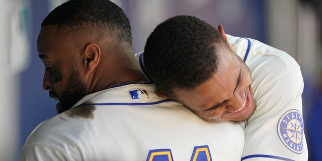 Seattle Mariners' Carlos Santana, sinistra, is hugged by Julio Rodriguez, destra, after Santana hit a two-run home run against the Toronto Blue Jays during the eighth inning of a baseball game, Domenica, luglio 10, 2022, a Seattle. Santana had two home runs and the Mariners won 6-5.