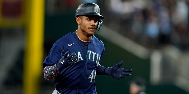 Seattle Mariners' Julio Rodriguez celebrates his grand slam against the Rangers, Friday, July 15, 2022, in Arlington, Texas.