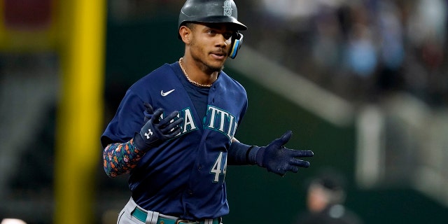 Seattle Mariners' Julio Rodriguez celebrates his grand slam against the Rangers, Friday, July 15, 2022, in Arlington, Texas.