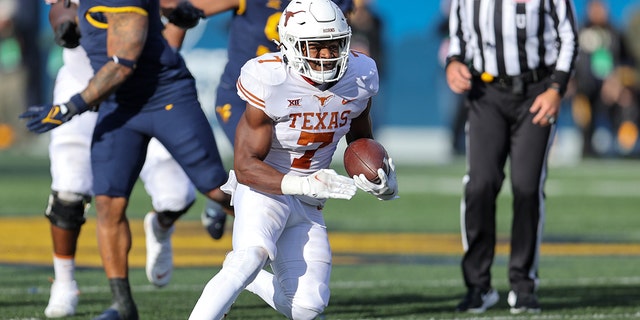 Texas Longhorns running back Keilan Robinson (7) carries the football during the fourth quarter of the college football game between the Texas Longhorns and the West Virginia Mountaineers on November 20, 2021, at Mountaineer Field at Milan Puskar Stadium in Morgantown, WV.