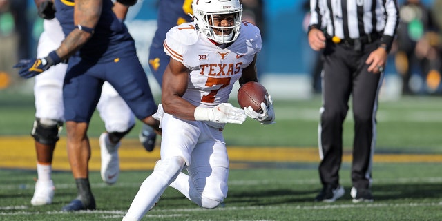 Texas Longhorns running back Keilan Robinson (7) carries the football during the fourth quarter of the college football game between the Texas Longhorns and the West Virginia Mountaineers on November 20, 2021, at Mountaineer Field at Milan Puskar Stadium in Morgantown, WV.