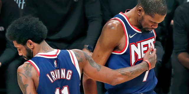 The Nets' Kyrie Irving pats teammate Kevin Durant during a Celtics game.