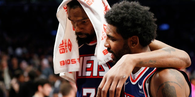 Kevin Durant and Kyrie Irving of the Nets talk during the Cleveland Cavaliers game at Barclays Center on April 8, 2022, in Brooklyn. 