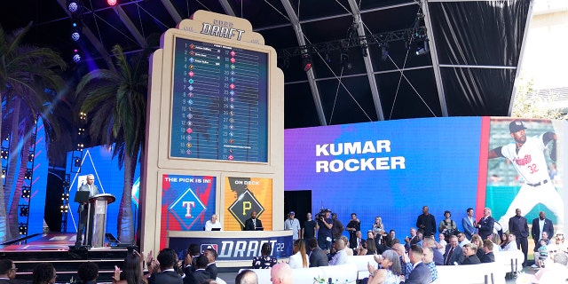 MLB Commissioner Rob Manfred, left, announces the selection of Kumar Rocker by the Texas Rangers with the third pick of the 2022 MLB baseball draft, Sunday, July 17, 2022, in Los Angeles.