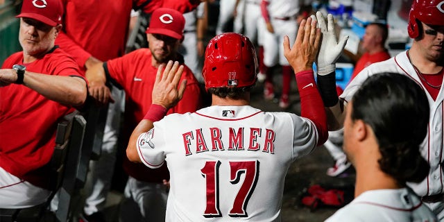 Cincinnati Reds' Kyle Farmer (17) celebrates with teammates after scoring on a Matt Reynolds single during the sixth inning of a baseball game against the Miami Marlins, Monday, July 25, 2022, in Cincinnati.