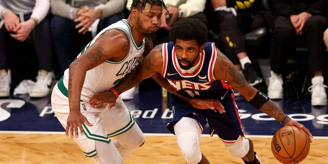 Kyrie Irving #11 of the Brooklyn Nets tries to get around Marcus Smart #36 of the Boston Celtics during Game Four of the Eastern Conference First Round Playoffs at Barclays Center on April 25, 2022 in the Brooklyn borough of New York City. The Boston Celtics defeated the Brooklyn Nets 116-112. 