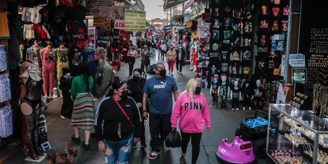 Los Angeles, CA, Friday, February 19, 2021 - Shoppers walk along Santee Alley late in the afternoon downtown. 