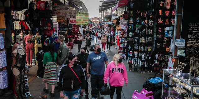 Los Angeles, CA, Friday, February 19, 2021 - Shoppers walk along Santee Alley late in the afternoon downtown. 