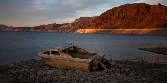 A formerly sunken boat sits high and dry along the shoreline of Lake Mead at the Lake Mead National Recreation Area.