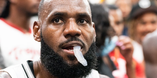 LeBron James is sitting during a time-out at the Drew League Pro-Am on July 16, 2022 in Los Angeles.