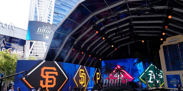 Logos from various teams are displayed during the 2022 MLB baseball draft, Sunday, July 17, 2022, in Los Angeles.