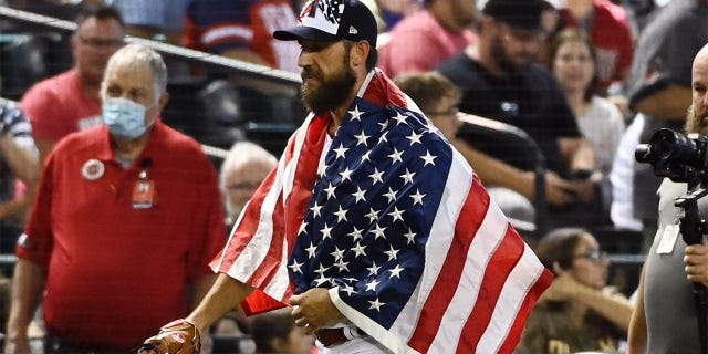 Pitcher Madison Bumgarner #40 of the Arizona Diamondbacks walks to the dugout wearing an American flag over his shoulders prior to a game against the San Francisco Giants at Chase Field on July 04, 2022 in Phoenix, Arizona. 