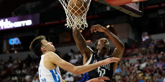 Orlando Magic's Emanuel Terry, right, dunks over Oklahoma City Thunder's Chet Holmgren during the second half an NBA summer league basketball game Monday, July 11, 2022, in Las Vegas.