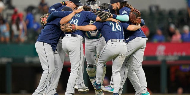 The Seattle Mariners dance in a circle after the final out of the baseball game against the Texas Rangers in Arlington, Texas, Sunday, July 17, 2022. The Mariners won 6-2.