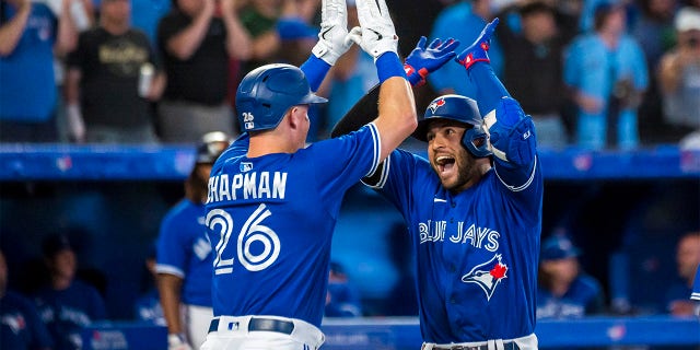 Toronto Blue Jays' George Springer (4) celebrates with Matt Chapman (26) after hitting a grand slam during the sixth inning of a baseball game against the St. Louis Cardinals, Tuesday, July 26, 2022 in Toronto.