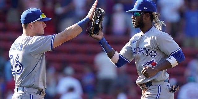 Toronto Blue Jays' Matt Chapman, left, celebrates with Raimel Tapia, right, after defeating the Boston Red Sox in a baseball game, Sunday, July 24, 2022, in Boston.