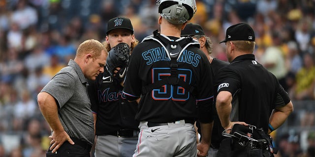 Max Meyer #23 of the Miami Marlins talks Jacob Stallings #58 and a trainer in the first inning during the game against the Pittsburgh Pirates at PNC Park on July 23, 2022 in Pittsburgh, Pennsylvania. 