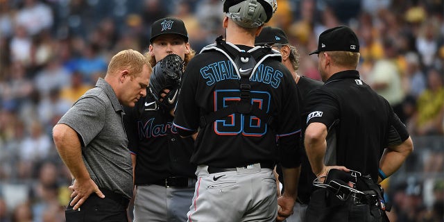 Max Meyer #23 of the Miami Marlins talks Jacob Stallings #58 and a trainer in the first inning during the game against the Pittsburgh Pirates at PNC Park on July 23, 2022 in Pittsburgh, Pennsylvania.