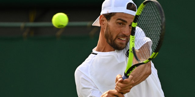 Maxime Cressy returns the ball to Canada's Felix Auger-Aliassime during their men's singles tennis match on the second day of the 2022 Wimbledon Championships at The All England Tennis Club in Wimbledon, southwest London, on June 28, 2022.