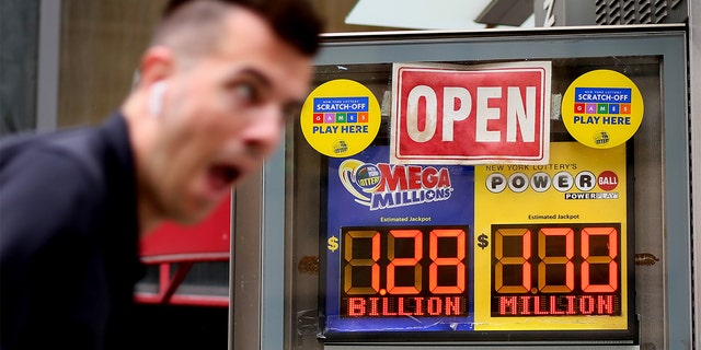 A man rides a bike past advertisements for the Mega Millions and Powerball lottery on July 29, 2022, in New York City.