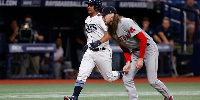 Tampa Bay Rays' Francisco Mejia runs past Boston Red Sox pitcher Matt Strahm to score during the sixth inning of a baseball game Tuesday July 12, 2022, in St. Petersburg, Fla.