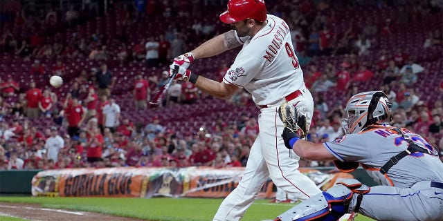 Mike Moustakas #9 of the Cincinnati Reds hits a walk-off sacrifice fly in the ninth inning to beat the New York Mets 1-0 at Great American Ball Park on July 05, 2022 in Cincinnati, Ohio.