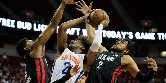 New York Knicks' Miles McBride, center, attempts a shot against Portland Trail Blazers' Brandon Williams, left, and Trendon Watford, right, during the first half an NBA summer league championship basketball game Sunday, July 17, 2022, in Las Vegas.