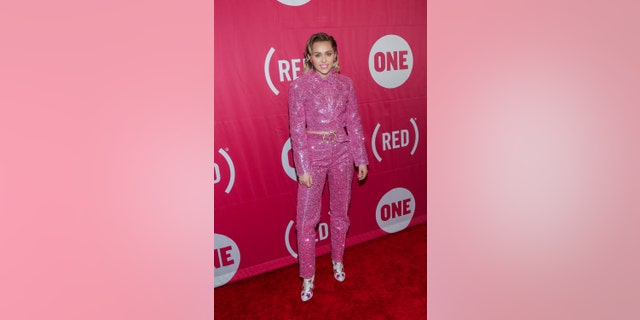 Recording artist Miley Cyrus attends ONE and (RED)'s "It Always Seems Impossible Until It Is Done" event dressed in Barbiecore.  