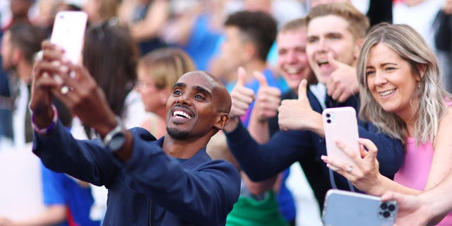 Sir Mo Farah of England takes a selfie with fans ahead of the Soccer Aid for Unicef 2022 match between England and the World XI at the London Stadium on June 12, 2022 in London, England.