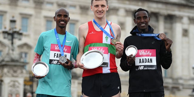 Gold medalist Ellis Cross, silver medalist Mo Farah and bronze medalist Mohamud Aadan pose on the podium after the elite men's race ahead of Mo Farah during the Vitality London 10,000m road race on May 2, 2022 in London, England.