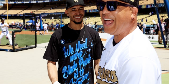 Mookie Betts #50 of the Los Angeles Dodgers speaks with manager Dave Roberts during batting practice ahead of the 92nd MLB All-Star Game presented by Mastercard at Dodger Stadium on July 19, 2022 in Los Angeles, California.