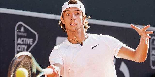 Italy's Lorenzo Musetti returns the ball to Spain's Carlos Alcaraz, during the final match of the Hamburg tennis tournament, Germany, Sunday July 24, 2022.