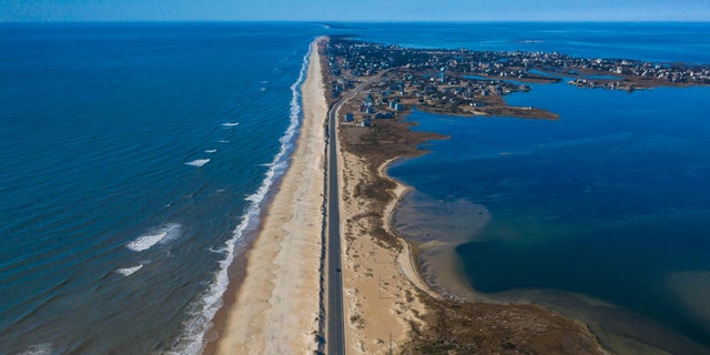 Drone aerial view of Outer Banks Highway 12 with Atlantic Ocean and Sound on both sides, Cape Hatteras National Seashore. 