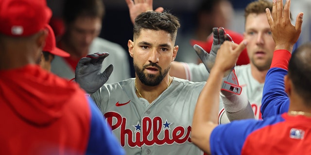 Nick Castellanos of the Philadelphia Phillies gives five to teammates during a game against the Miami Marlins at LoanDepot Park on July 15, 2022 in Miami, Florida.