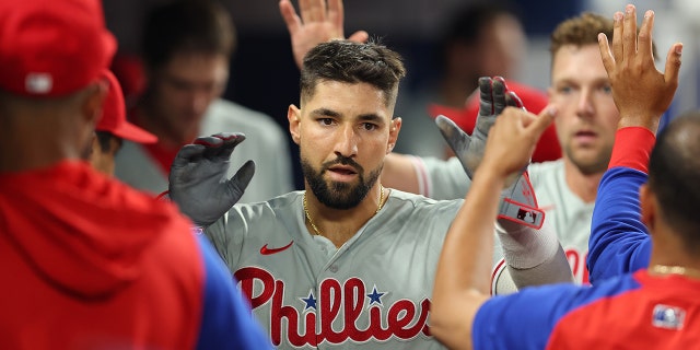 Nick Castellanos of the Philadelphia Phillies high-fives teammates during a game against the Miami Marlins at LoanDepot Park July 15, 2022, in Miami, Fla.