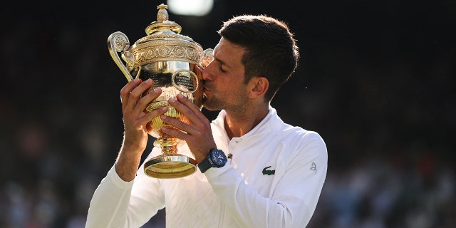 Serbia's Novak Djokovic kisses his trophy after defeating Australia's Nick Kyrgios in the Wimbledon men's singles final at the All England Tennis Club in London July 10, 2022.