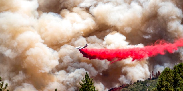 An air tanker drops retardant while trying to stop the Oak Fire from progressing in Mariposa County, Calif., on Sunday, July 24, 2022.