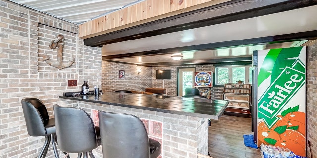 The home includes two kitchens (one is pictured here) — plus an indoor pool and other amenities.