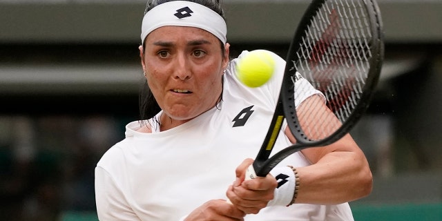 Tunisia's Ons Jabeur returns the ball to Belgium's Elise Mertens during a fourth round women's singles match on day seven of the Wimbledon tennis championships in London, Sunday, July 3, 2022.