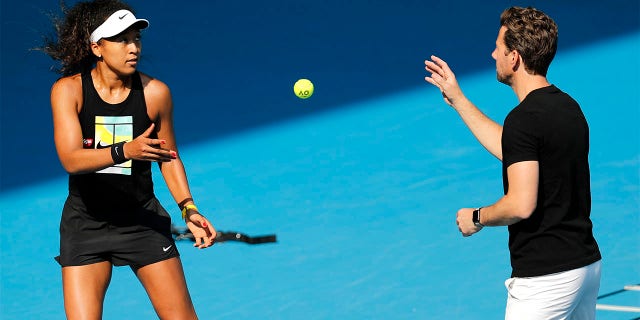Japan's Naomi Osaka warms-up with her coach Wim Fissette during a practice session ahead of the Australian Open tennis championship in Melbourne, Australia, on Jan. 19, 2020. Osaka is in need of a new coach. Fissette wrote on Instagram on Wednesday, July 20, 2022, that they are ending their partnership.