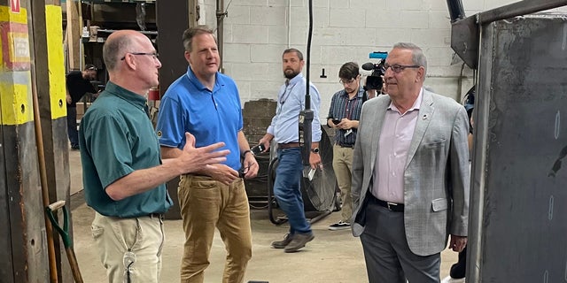 Former Maine governor and 2022 GOP gubernatorial nominee Paul LePage (right) and GOP Gov.  Chris Sununu of New Hampshire (center) gets a tour of Messer Truck Equipment in Westbrook, Maine on July 13, 2022