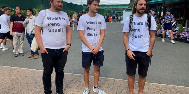 From left Protesters Will Hoyles, 39, Caleb Compton, 27, and Jason Leith, 34, who all work for Free Tibet pose for the media in T-shirts reading "Where is Peng Shuai", at the Wimbledon Tennis tournament in London, Monday, July 4, 2022.