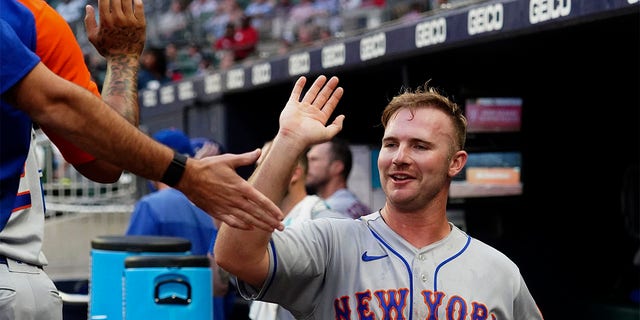 New York Mets' Pete Alonso (20) celebrates in the dugout after scoring on a Luis Guillorme ground ball in the third inning of a baseball game against the Atlanta Braves, Monday, July 11, 2022, in Atlanta. 