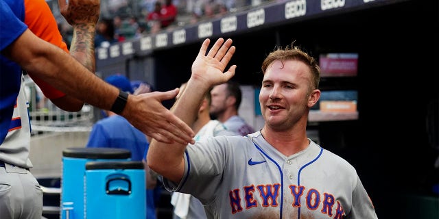New York Mets' Pete Alonso (20) celebrates in the dugout after scoring on a Luis Guillorme ground ball in the third inning of a baseball game against the Atlanta Braves, Monday, July 11, 2022, in Atlanta.
