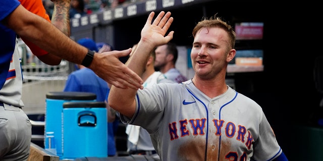 New York Mets' Pete Alonso celebrates in the dugout after scoring on a Luis Guillorme ground ball against the Braves, Monday, July 11, 2022, in Atlanta.