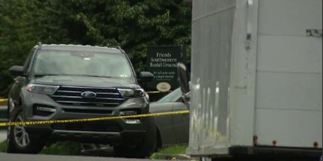 Authorities rope off the scene where two men were killed during a funeral procession near Philadelphia on Friday.